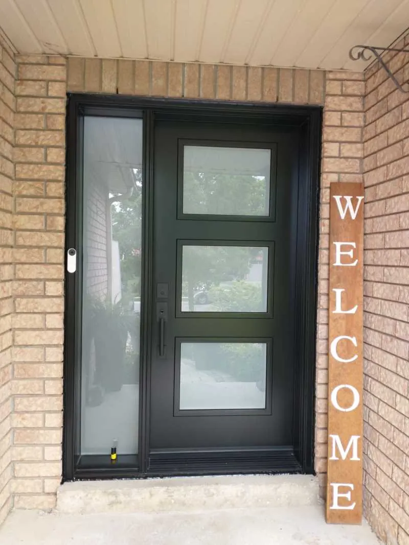 Black front door with three frosted glass panels and a sidelight in a brick entry, installed by Panorama Windows & Doors Black front door with three frosted glass panels and a sidelight in a brick entry
