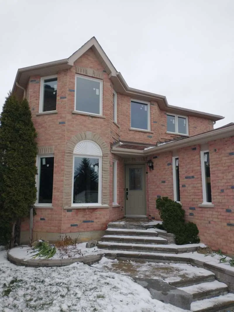 Two-storey brick home with new white windows and an arched window, installed by Panorama Windows & Doors Two-storey brick home with new white windows and an arched window