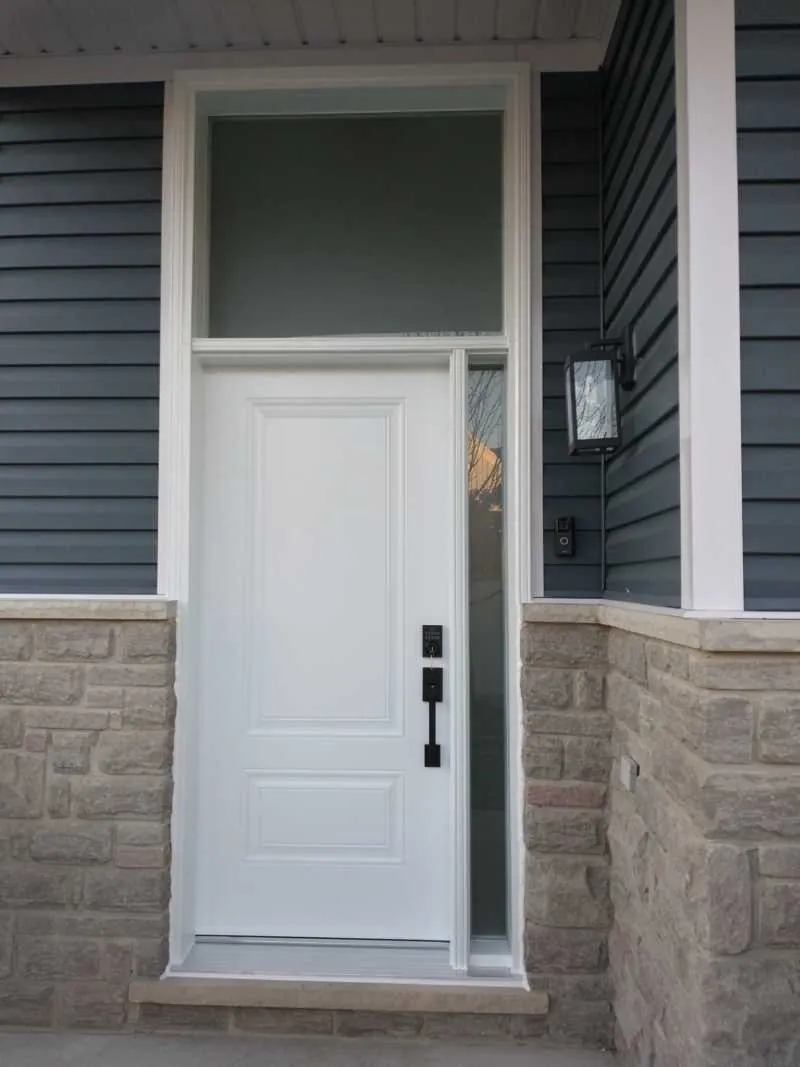 White entry door with a sidelight and transom on stone