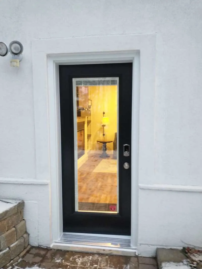 Black full-glass door on a white stucco wall