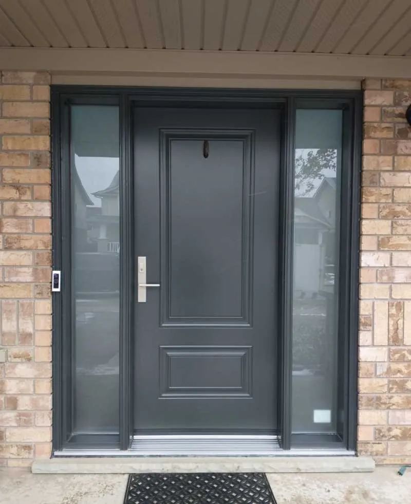 Black entry door with two sidelights on yellow brick