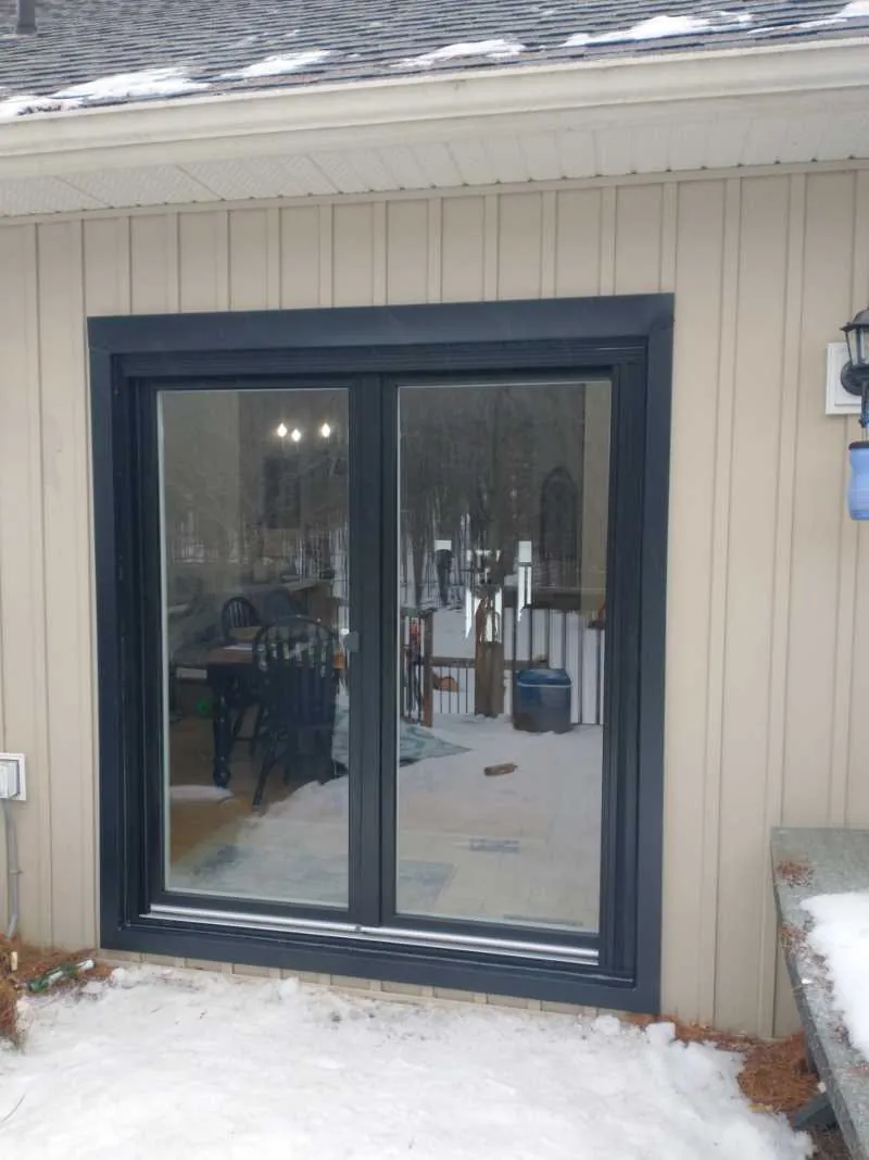 Black French doors on a siding wall