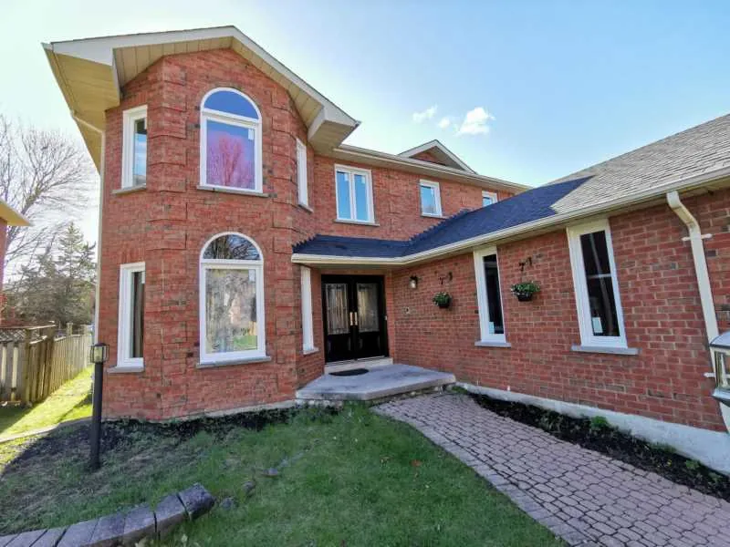 New windows on a red brick two-storey home with arched windows