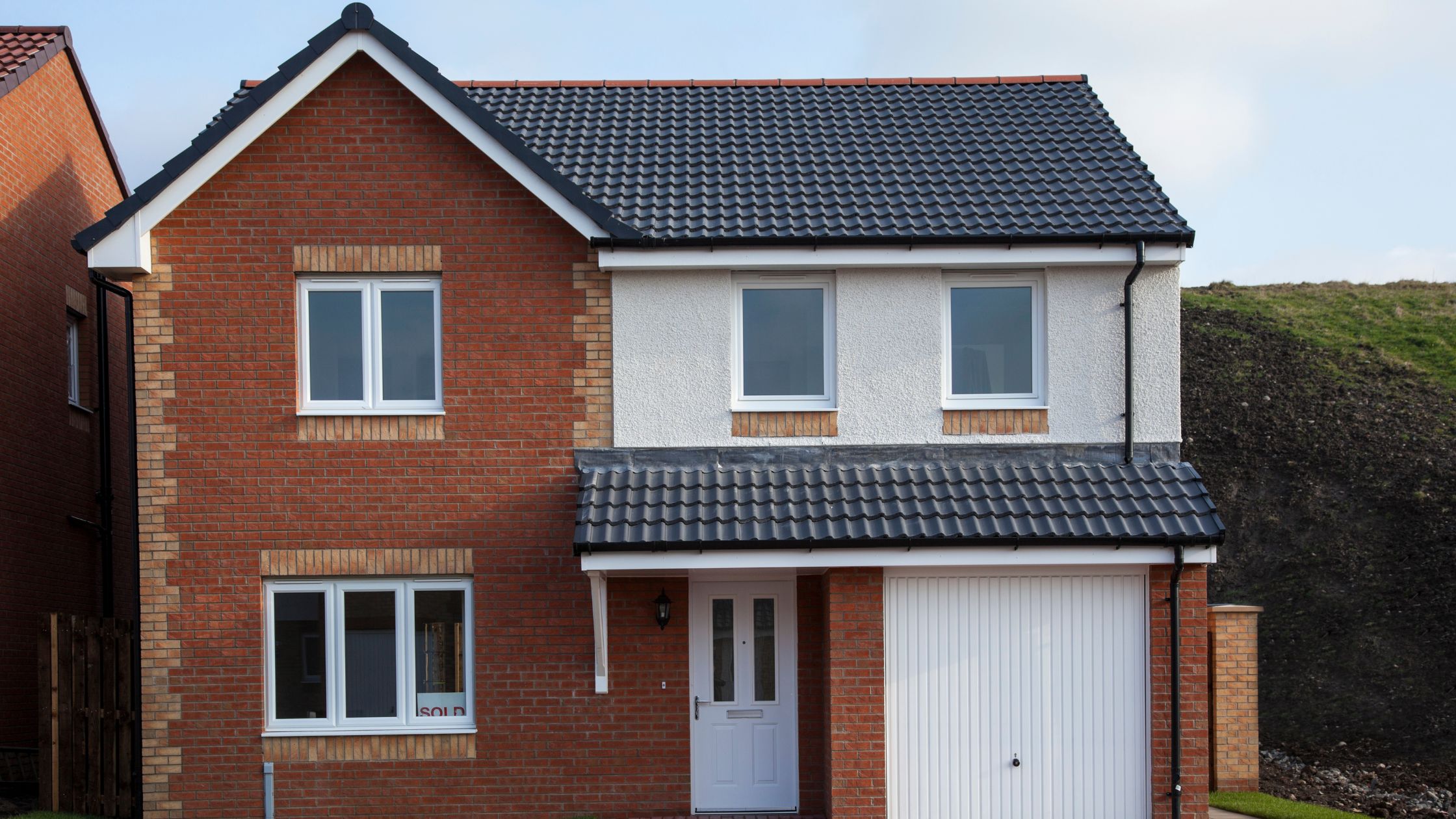 Brick and stucco Ontario home showing different types of windows including white vinyl casement and sliding styles with black tiled roof