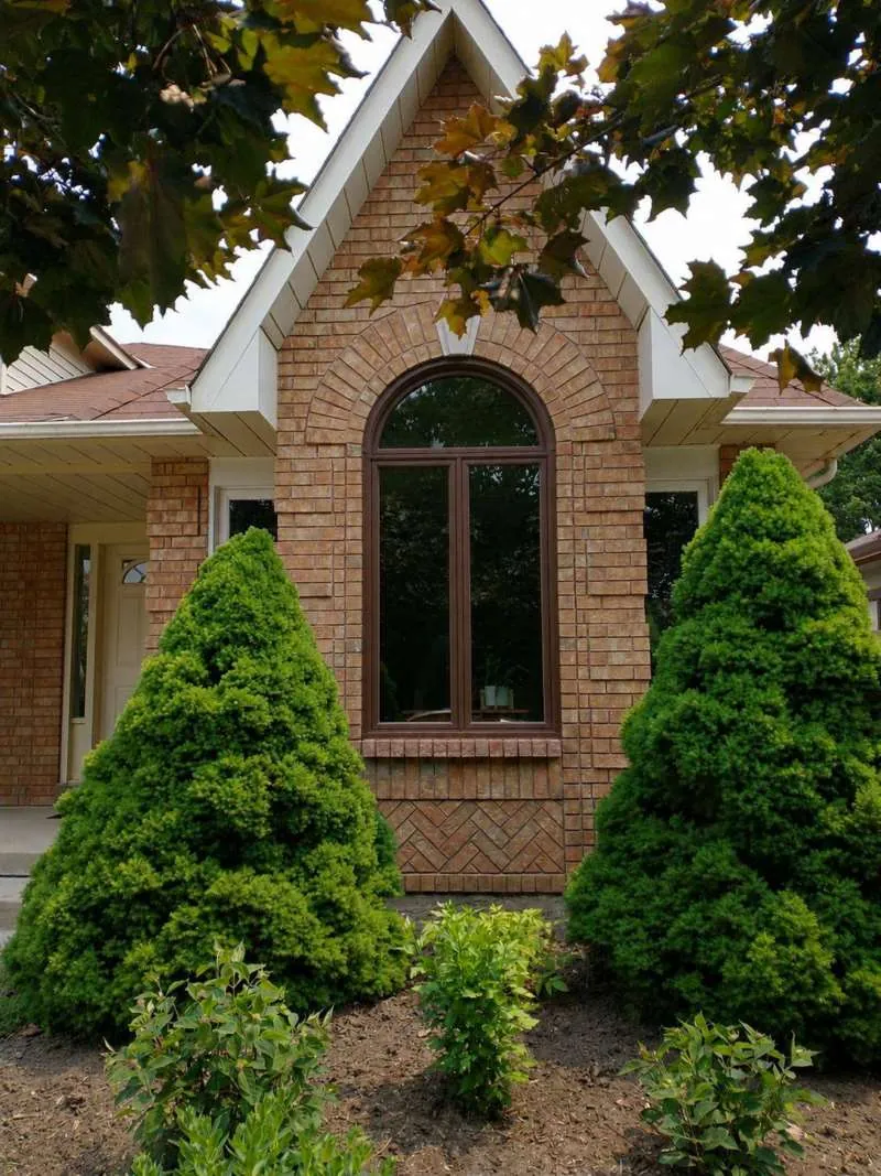 Arched Window Replacement: after The same Barrie bungalow with a new brown arched window, after replacement