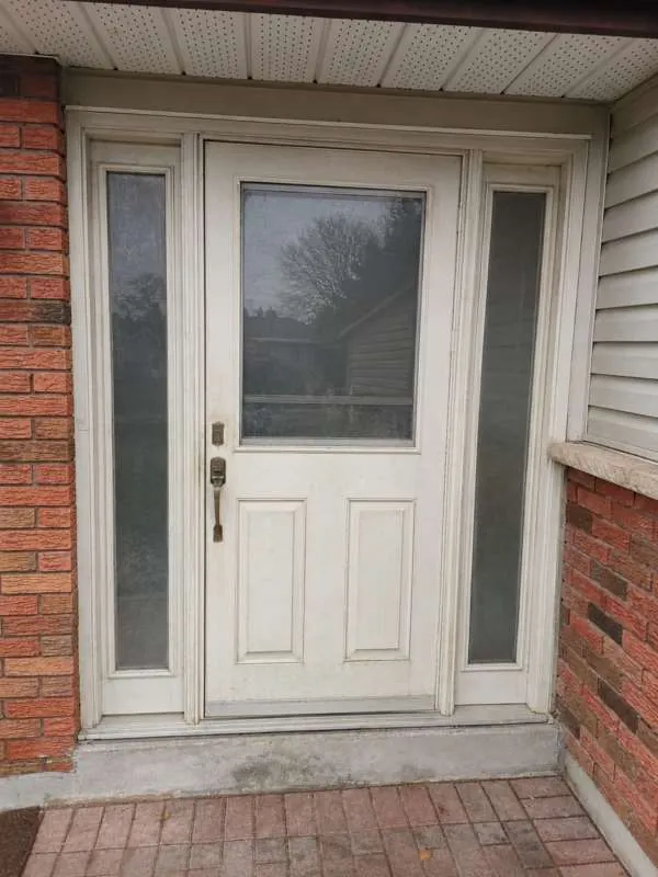 Front Entry Door Upgrade: before White front door with two sidelights on an Alliston home, before replacement
