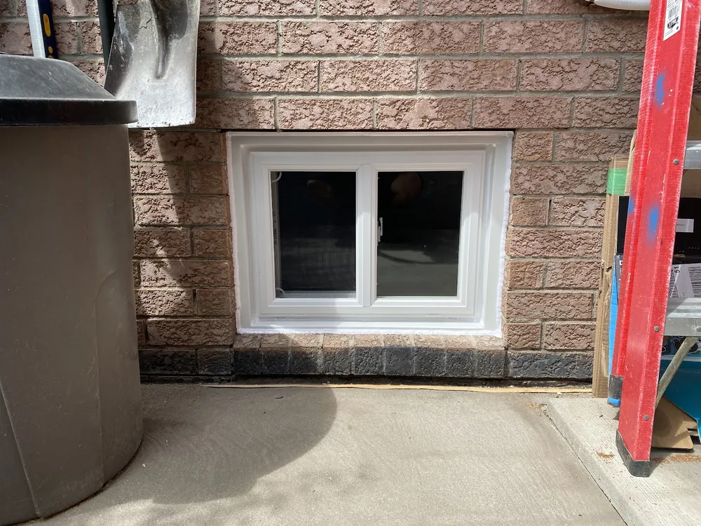 Basement slider window on a brick wall
