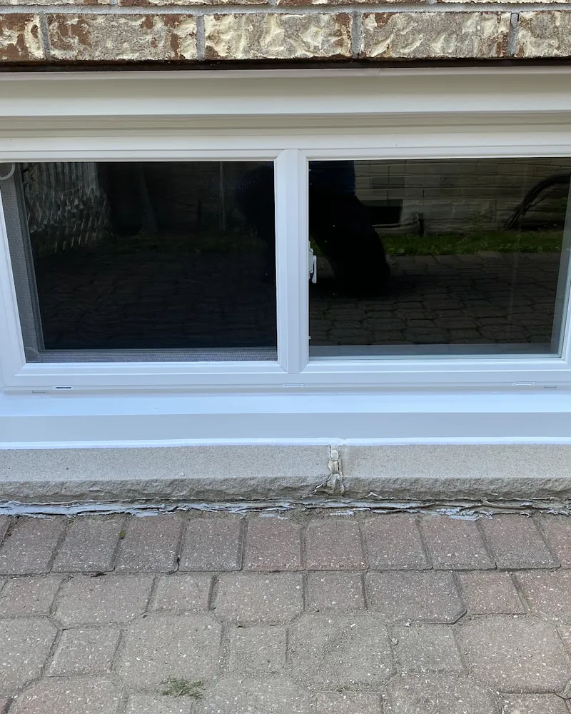 Basement Slider Window Replaced: after Basement window above a paved patio after replacement