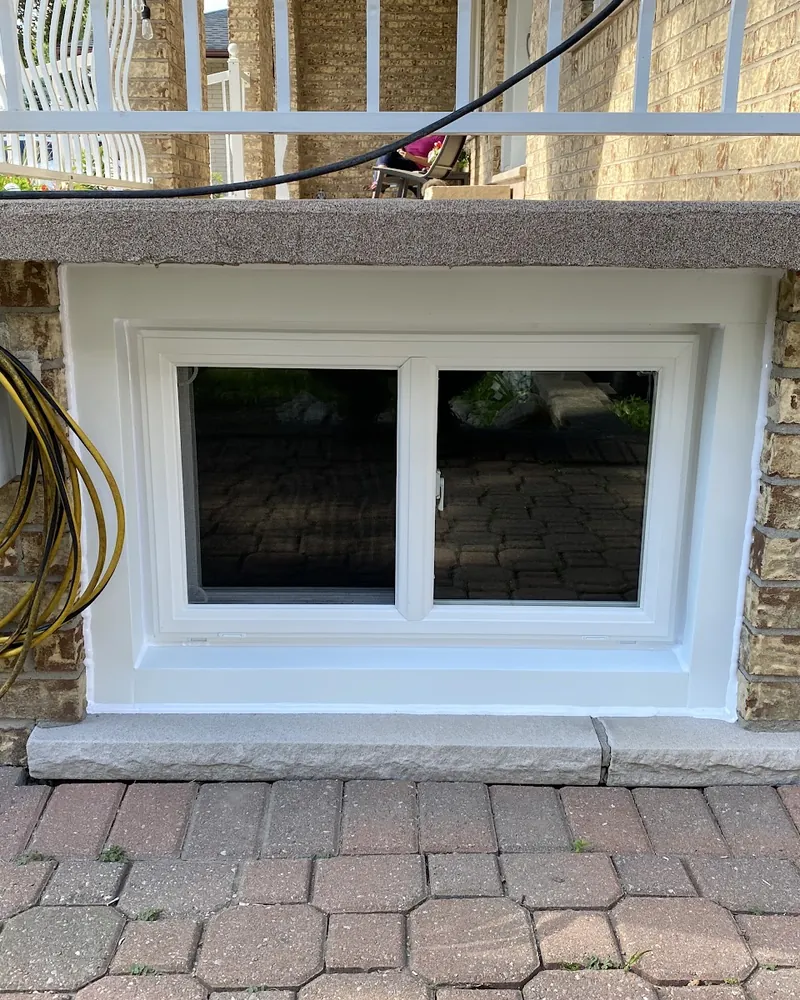 Basement Window Replacement: after Basement window on a brick wall after replacement in Oshawa