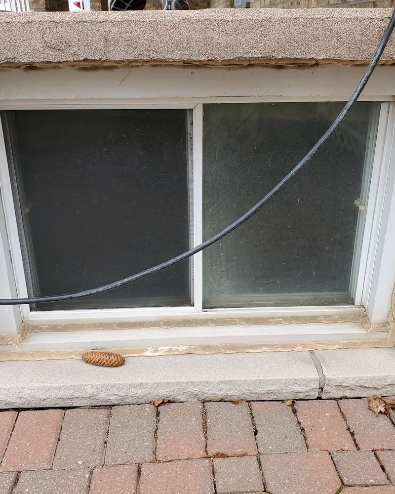 Basement Window Replacement: before Basement window on a brick wall before replacement in Oshawa