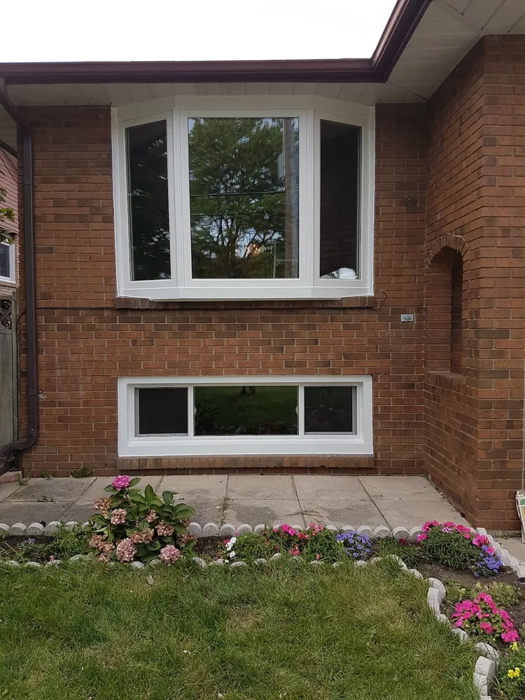 Bow window with a basement slider on red brick in Hamilton