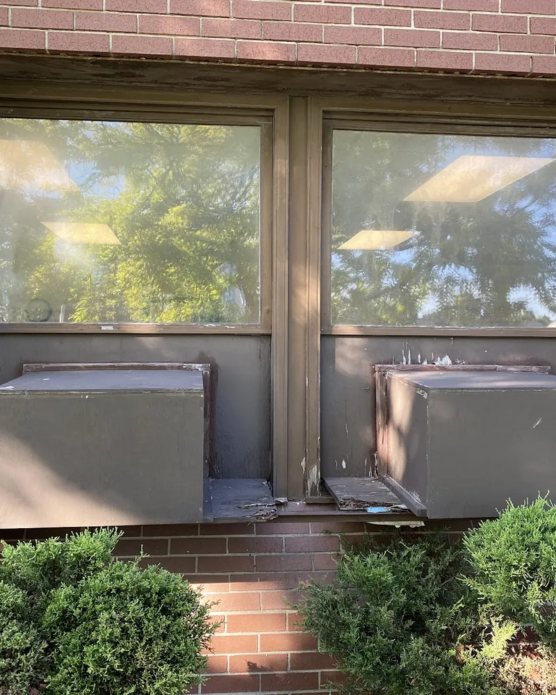 Commercial Windows Without the Wall AC Units: before Two windows on a brick building before replacement in Brampton