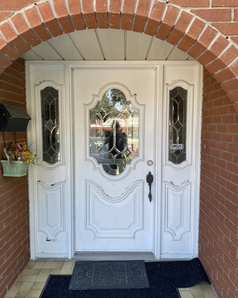 Ornate Entry Door to Modern Grey Door: before Entry door with two sidelights under a brick arch before replacement
