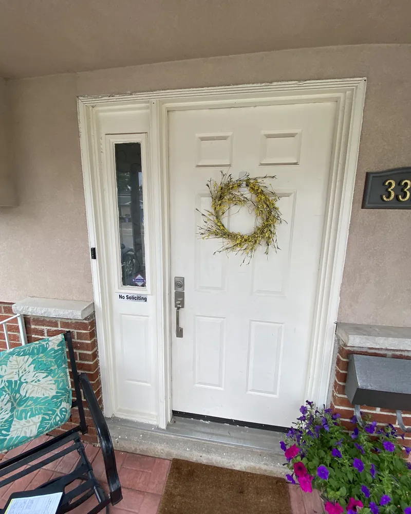 Front Door and Sidelight Upgrade: before Front door with a sidelight on a stucco porch before replacement in Burlington