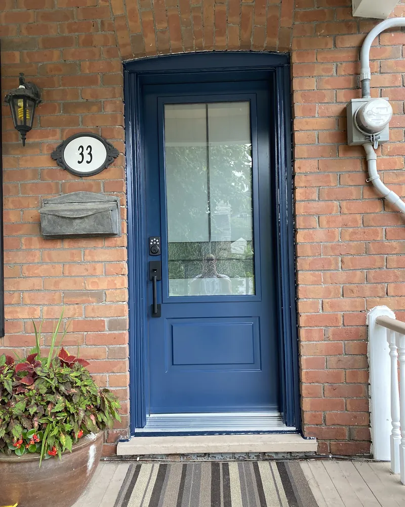 Grey Front Door to Navy Door With Glass: after Front door on a brick porch after replacement