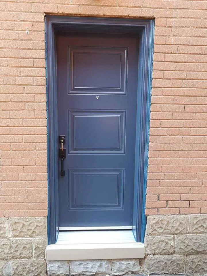 Navy four-panel steel entry door on red brick