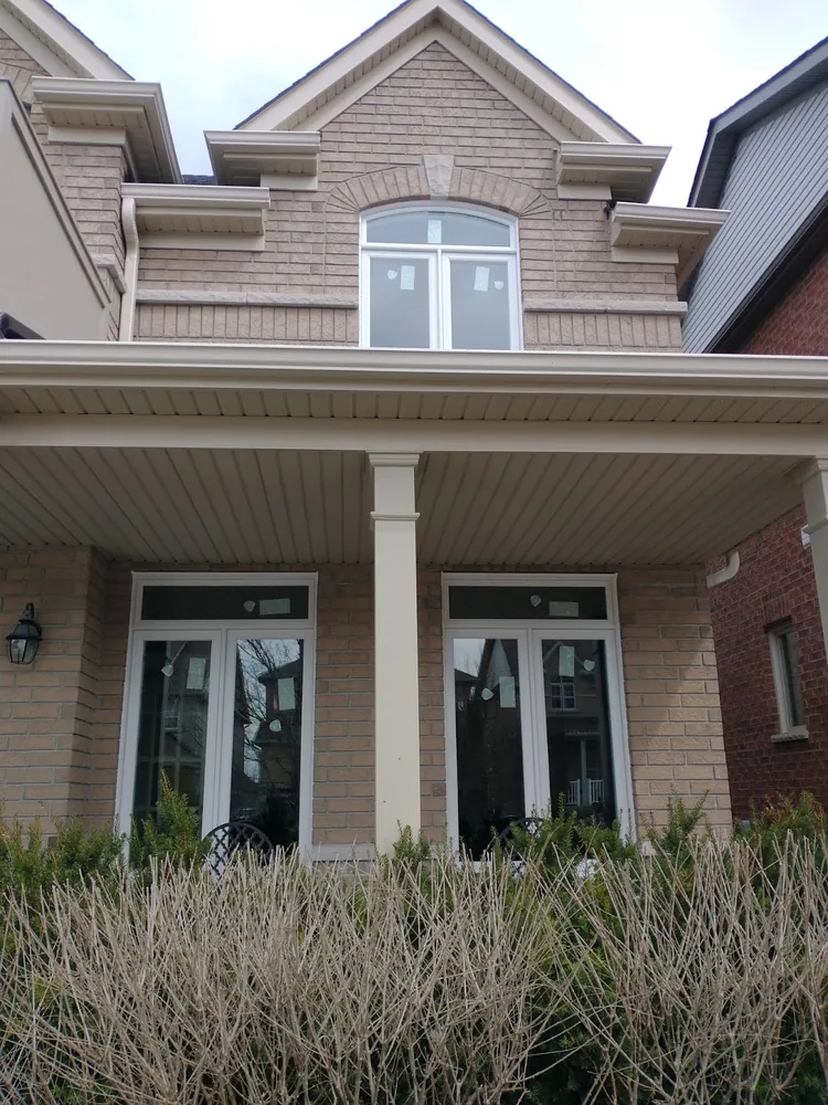 Two pairs of white French doors on a brick porch