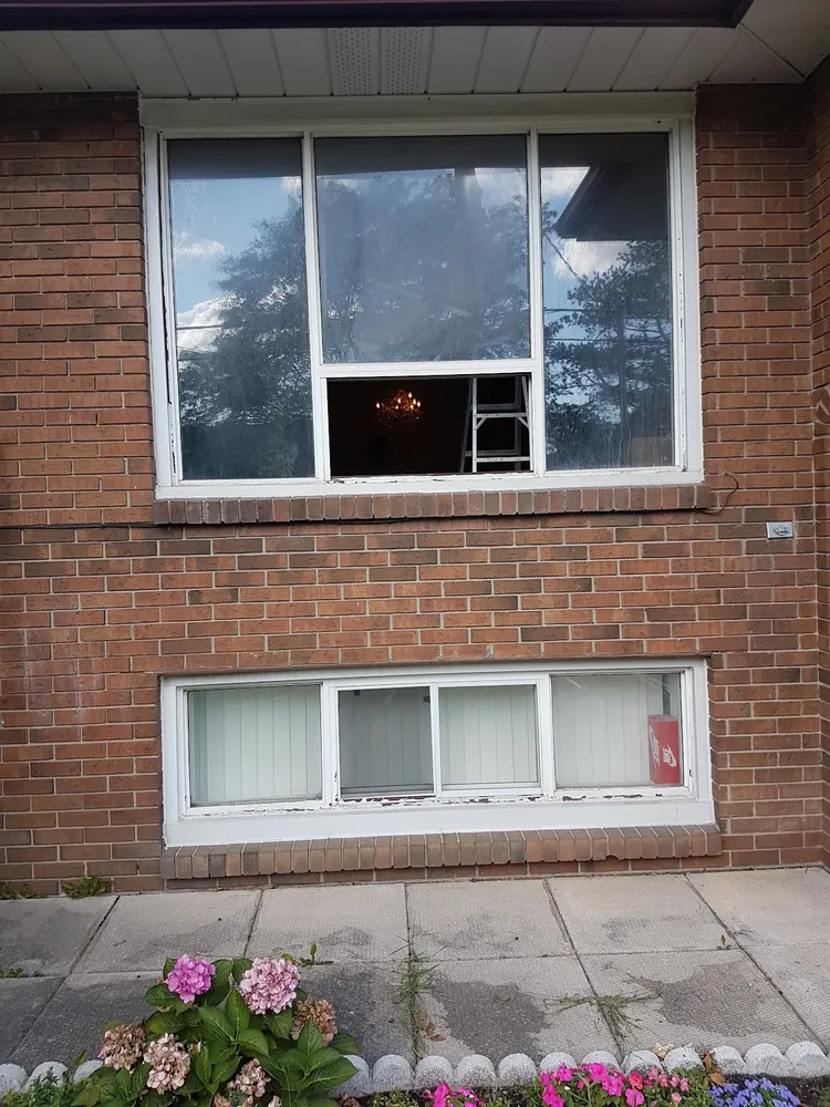 Picture window and basement window on red brick in Hamilton