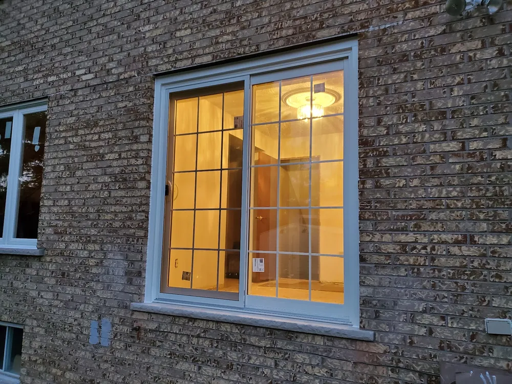 Slider window with colonial grilles on a brick wall