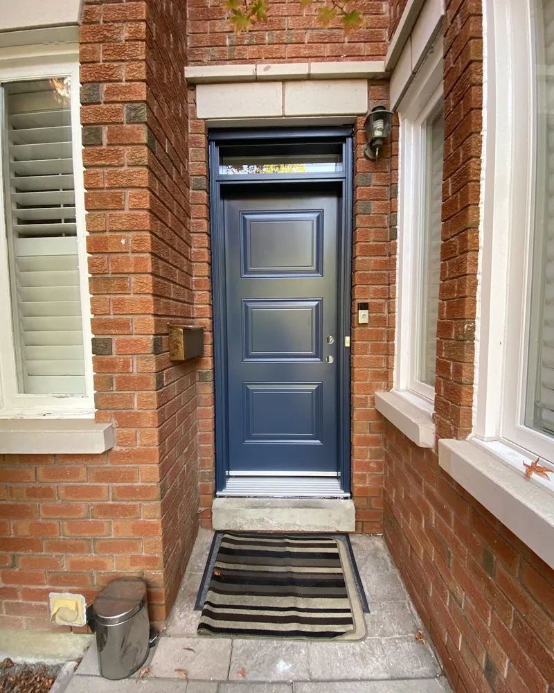 Front door with a transom on a brick wall after replacement