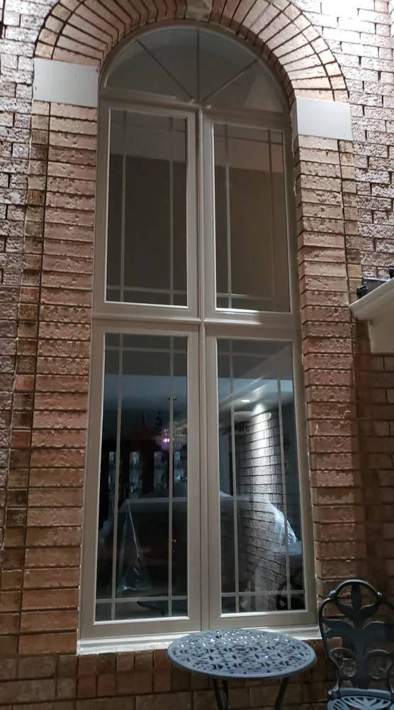 Tall arched window stack on brick, installed by Panorama Windows & Doors Tall arched window stack on brick
