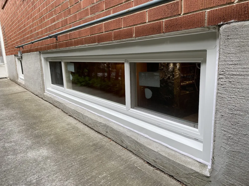 Three-pane end vent slider basement window