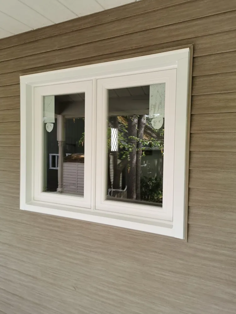 White casement windows on taupe siding
