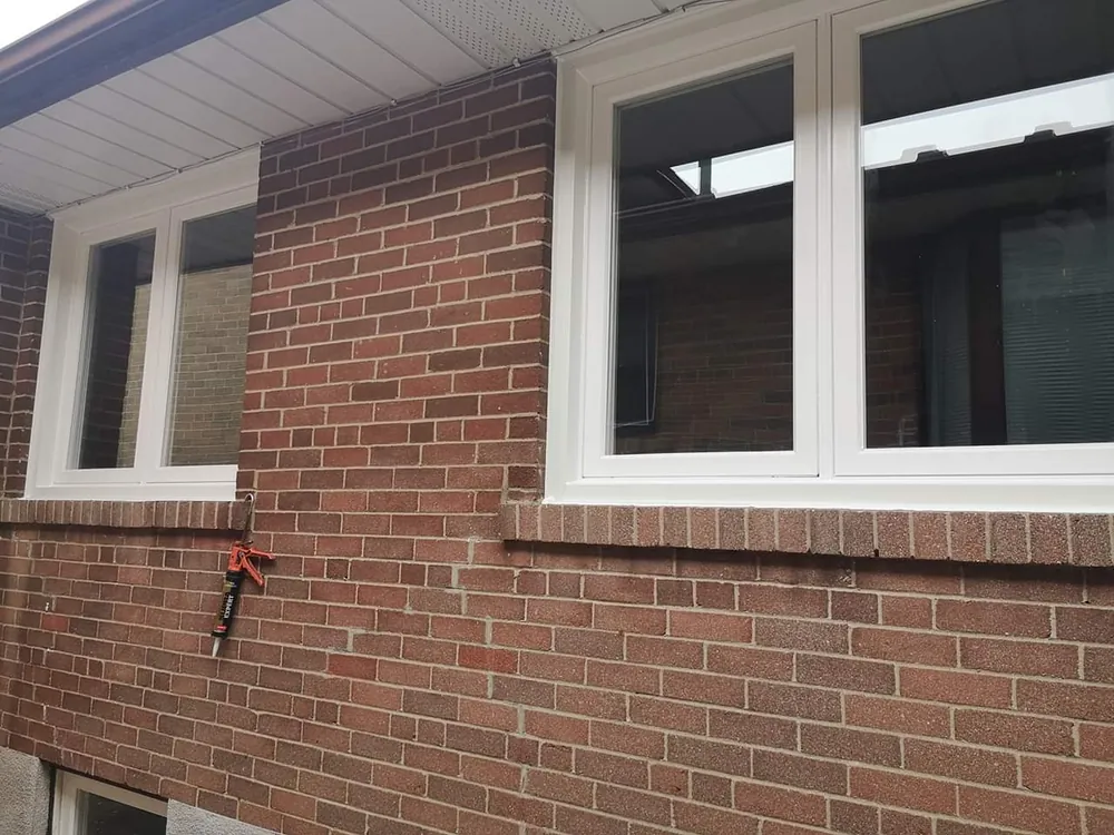 White vinyl casement windows on a brick home installed by Panorama Windows & Doors White vinyl casement windows on a brick home