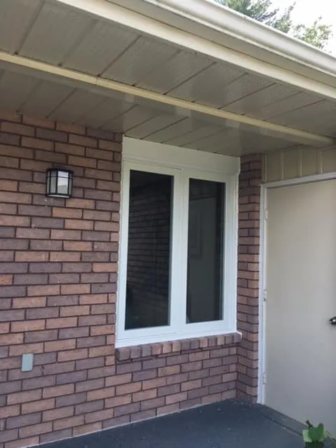 White vinyl casement windows on red brick installed by Panorama Windows & Doors White vinyl casement windows on red brick