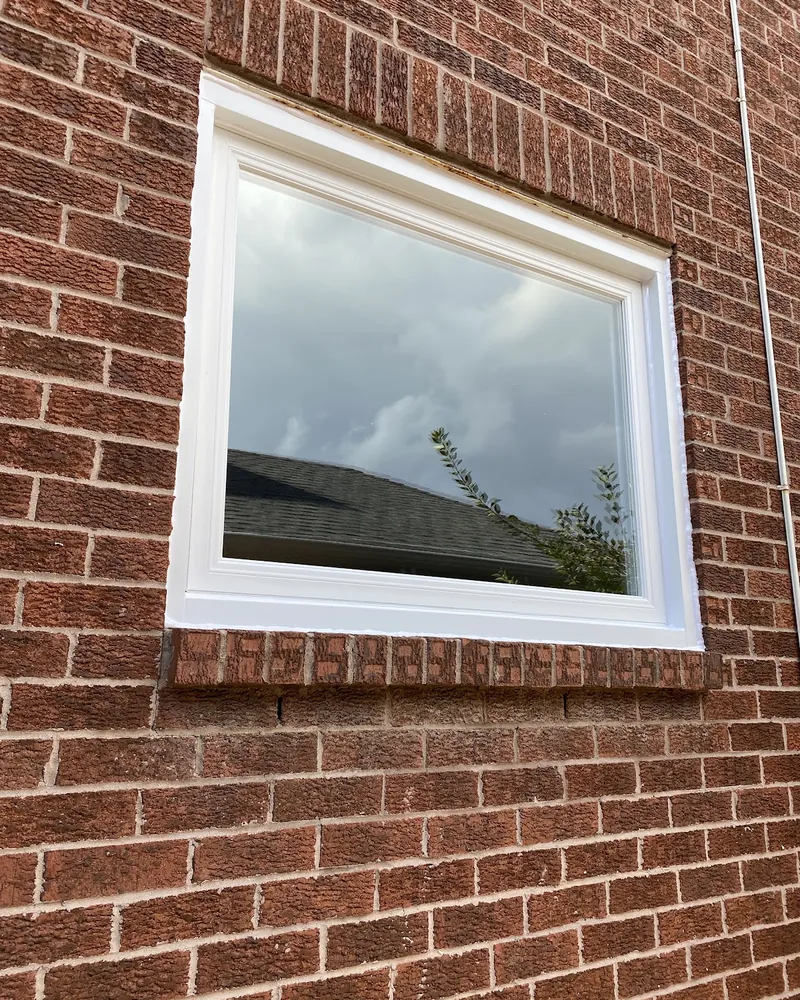 Brown Frame Window to White Vinyl: after Large window on a brick wall after replacement in Brampton