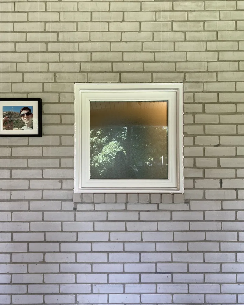 Frosted Slider to New Window: after Window on a painted brick wall after replacement